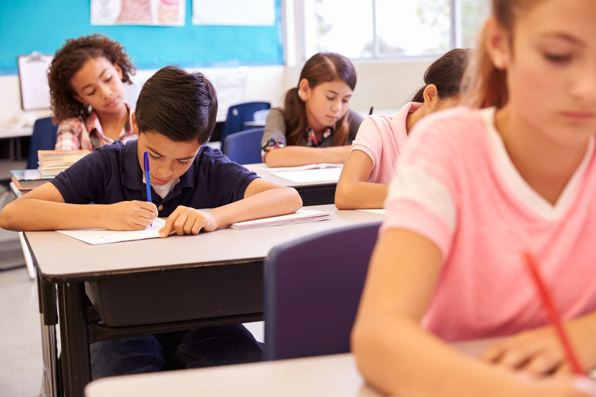 Elementary school kids working at their desks in a classroom