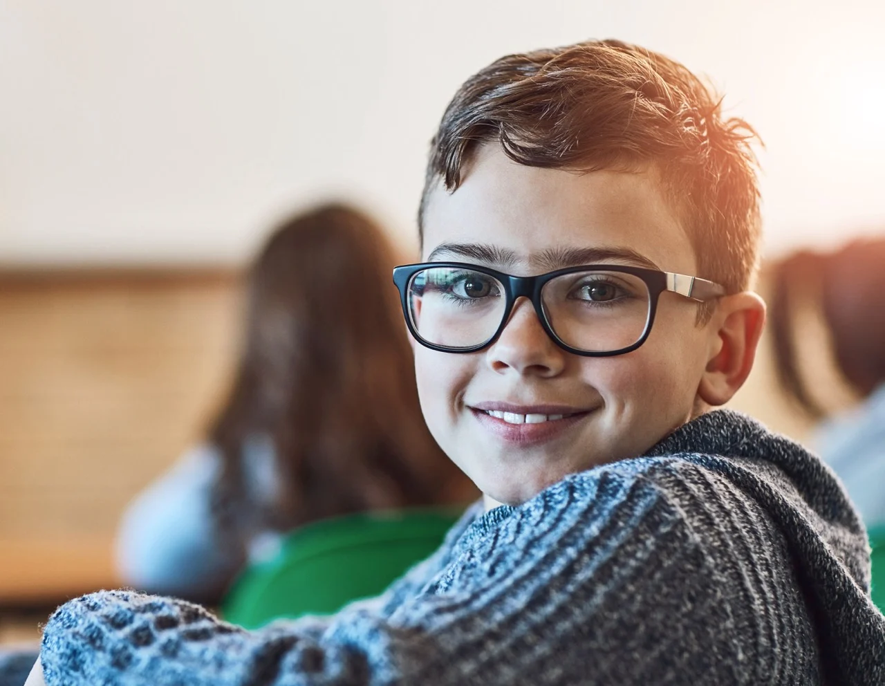 Boy, class and portrait of face with glasses for education, learning and development in junior school. Male learner, smile and knowledge in classroom for subject, growth and happiness for information